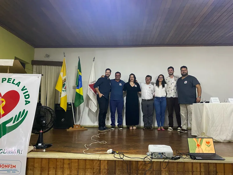 Equipe de saúde reunida no palco ao lado do banner Bonfim pela Vida