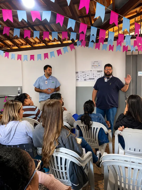 Dr. Sérgio fala para a equipe do CAPS durante uma capacitação, sob bandeirinhas coloridas