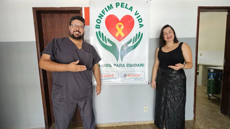Dr. Sérgio e uma colega apresentam o banner Bonfim pela Vida, Unidos para Cuidar