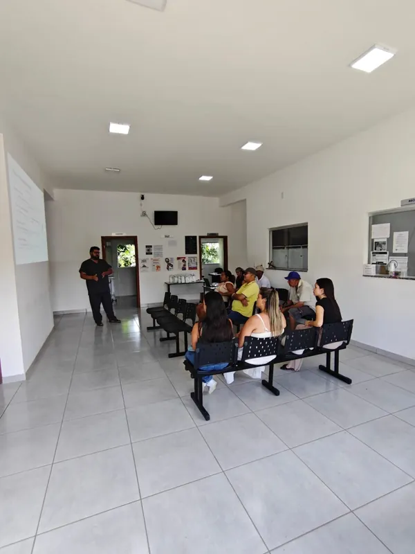 Usuários sentados na sala de espera da UBS ouvem uma conversa em saúde