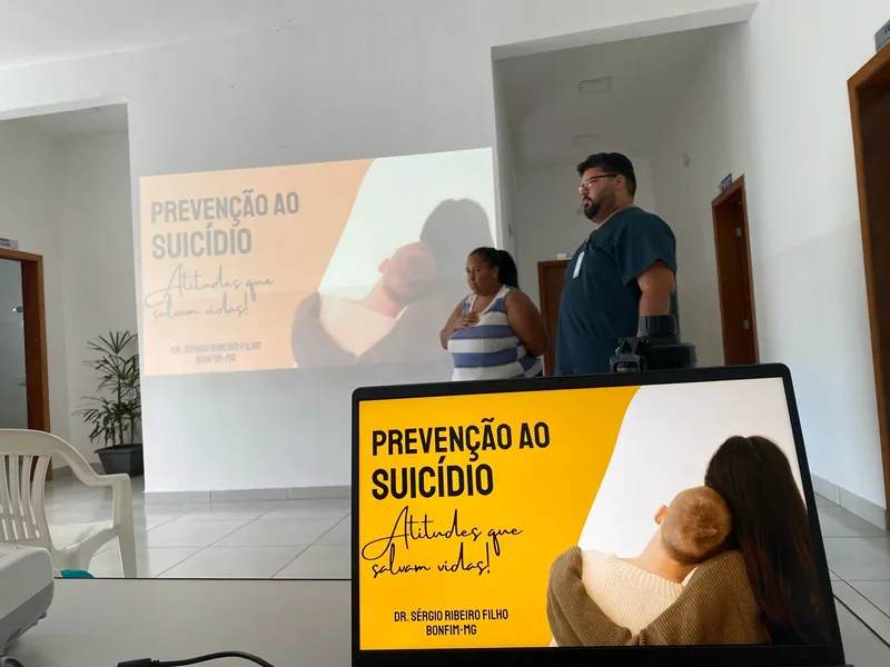 Dr. Sérgio ao lado da tela Prevenção ao suicídio, atitudes que salvam vidas